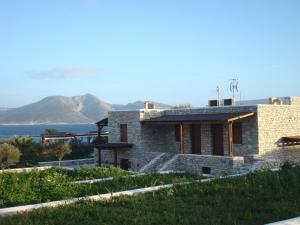 a stone house with mountains in the background at Nektarios Fanos Studios in Koufonisia