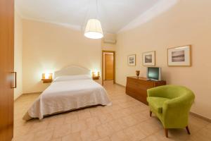 ein Schlafzimmer mit einem Bett, einem Stuhl und einem TV in der Unterkunft La Residenza in Neapel
