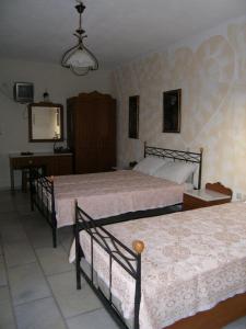 a bedroom with two beds and a table and a mirror at Fanos Studios in Koufonisia