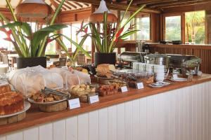 un buffet de bollería y otros alimentos en una barra en Carambola Hotel en Arraial d'Ajuda