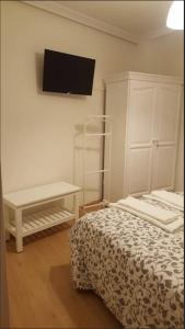 a bedroom with a bed and a tv on the wall at Piso en el casco antiguo in Zamora