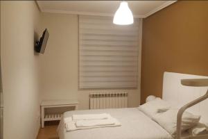 a small bedroom with a bed and a window at Piso en el casco antiguo in Zamora