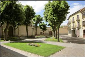 a courtyard with trees and grass and a building at Piso en el casco antiguo in Zamora