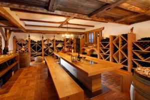 a large wine cellar with wooden tables and wine bottles at Hotel Ratschingserhof in Racines