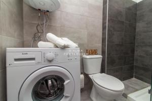 a bathroom with a washing machine and a toilet at Armação de Pêra Apartment- D´Alma Ouro in Armação de Pêra