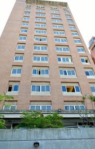 a tall brick building with windows on the side of it at Hotel Coliseo in Caracas