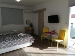 a bedroom with a bed and a table and chairs at Chicos Studios in Ayia Napa