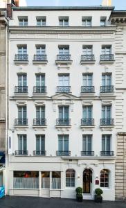fachada blanca de un edificio con balcones en Best Western Premier Faubourg 88, en París