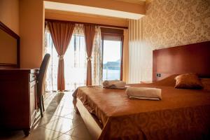 ein Hotelzimmer mit einem Bett und einem großen Fenster in der Unterkunft Hotel Velkom in Sutomore