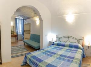 - une chambre avec un lit et une chaise bleue dans l'établissement Domus Napoleone Bonaparte, à Sanremo