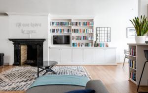 ein Wohnzimmer mit einem Kamin und einem TV in der Unterkunft The Paddington Mews - Comfortable & Elegant 3BDR Paddington Mews in London
