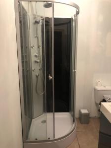 a shower with a glass door in a bathroom at Appartement centre Granville in Granville