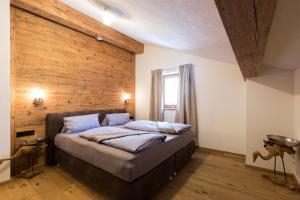 Bett in einem Zimmer mit einer Holzwand in der Unterkunft Ferienwohnung Hausegg in Haiming
