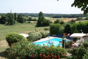 a swimming pool in a garden with people in it at Domaine La Fontaine B&B in Soubran
