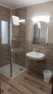La salle de bains est pourvue d'une douche, d'un lavabo et d'un miroir. dans l'établissement Orchidea II, à Hévíz