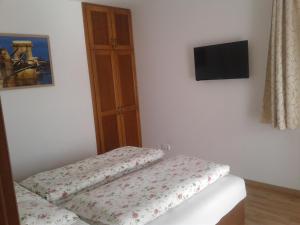 a room with a bed and a flat screen tv at Orchidea II in Hévíz