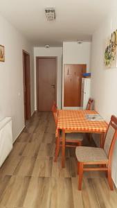 een kamer met een tafel en stoelen en een keuken bij Orchidea II in Hévíz