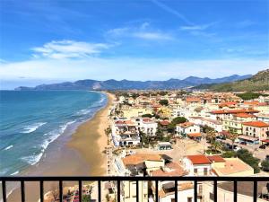 Una vista de una playa con casas y el océano. en holidaycasa Brandy- A picco sul mare, en Sperlonga