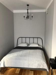 - une chambre avec un lit et un lustre dans l'établissement CR Cichy Apartament w Centrum, à Białystok