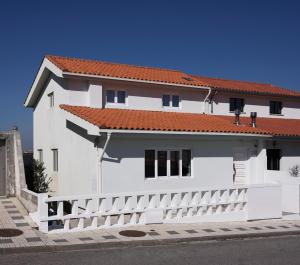 a white house with a white picket fence at BeachLiving Cortegaça in Cortegaça