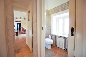 Un baño con inodoro y ventana. en holidaycasa Brandy- A picco sul mare, en Sperlonga 24 fotos más