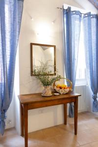 einen Spiegel und eine Schale Obst auf dem Tisch in der Unterkunft Domus Napoleone Bonaparte in Sanremo