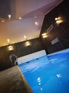 uma piscina com um banco e luzes num quarto em Hôtel/Restaurant C'Vall em Urepel