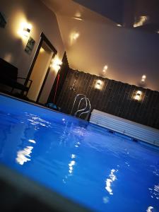- une piscine bleue dans une maison la nuit dans l'établissement Hôtel/Restaurant C'Vall, à Urepel