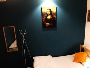 a blue wall with a painting of a woman on it at Bla Bla Rooms in Krasnodar