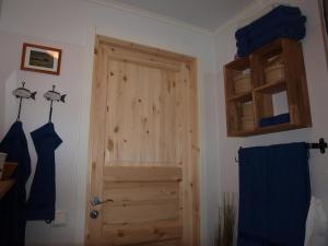 baño con puerta de madera en una habitación en Cabin on Husky Farm, en Strömsund