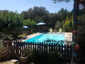 een zwembad in een tuin met een hek bij L'OLIVERAIE EN PROVENCE in Lambesc