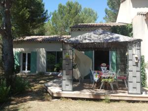 a house with a patio with chairs and a table at L'OLIVERAIE EN PROVENCE in Lambesc