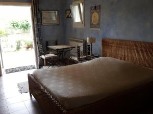 een slaapkamer met een bed en een tafel met stoelen bij L'OLIVERAIE EN PROVENCE in Lambesc