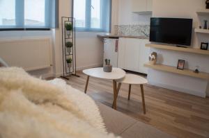 Una sala de estar con una mesa y un televisor. en Central GREEN HOUSE, en Bucarest
