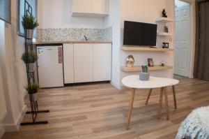 Una sala de estar con una mesa y un refrigerador. en Central GREEN HOUSE, en Bucarest