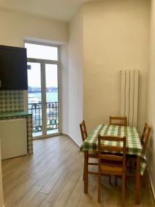 una sala da pranzo con tavolo e sedie e un balcone di Casa Annamaria a Napoli