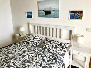 una camera da letto con un letto con un piumone bianco e nero di Casa Annamaria a Napoli