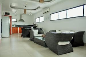 a living room with a couch and chairs and windows at Hoteles en Guayaquil - Suites Guayaquil Cerca del Aeropuerto in Guayaquil