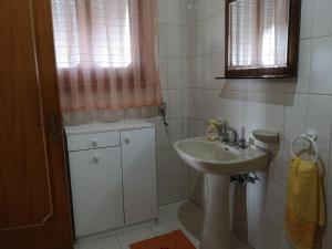 a white bathroom with a sink and a window at Holiday House in Taviano +33 photos