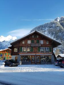 ein großes Holzgebäude mit davor geparkt in der Unterkunft Chalet am Irfig in Kandersteg