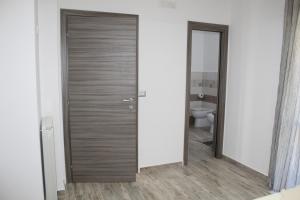 eine Holztür im Bad mit WC in der Unterkunft B&B Momentidì in Paestum