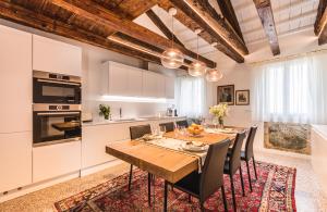 cocina y comedor con mesa de madera y sillas en Apartment Cà Brunilda-luxury penthouse with terrace, en Venecia
