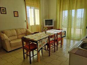 a living room with a table with chairs and a couch at Holiday House in Taviano
