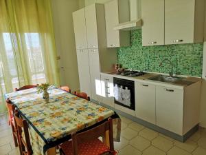 a kitchen with a table and a sink and a stove at Holiday House in Taviano