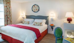 a bedroom with a large bed with red and white sheets at Relais des Trois Châteaux Hôtel-Restaurant - Teritoria in Cour-Cheverny