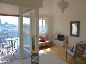 ein Wohnzimmer mit einem Balkon mit einem Sofa und einem TV in der Unterkunft Top Flat in Porto