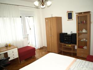 une chambre avec un lit, un bureau et une télévision dans l'établissement Apartman Jelinić, à Split
