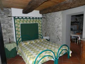 sypialnia z zielonym łóżkiem w kamiennej ścianie w obiekcie Terrazza sul Golfo w mieście La Spezia