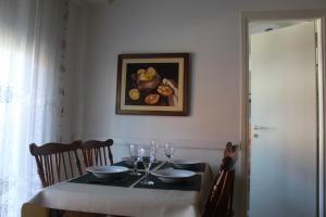 una mesa con copas de vino y una pintura en la pared en Departamento en barrio Stella Maris-Zona Playa Varese en Mar del Plata