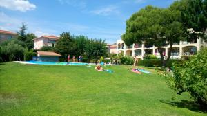 a group of people laying on the grass in a park at VIDABRAVA Sagaro garden, Jardin privado, piscina, 150 m playa in S'agaro